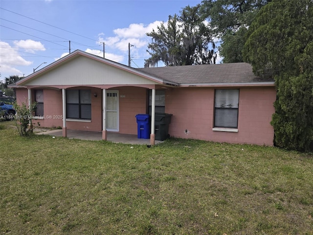 1521 Richmond Rd, Lakeland, FL 33805 - back of house with concrete block siding, a lawn, roof with shingles, and a patio