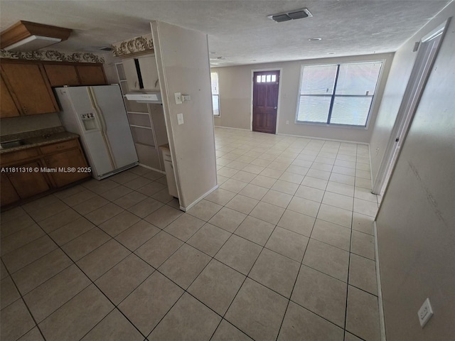 1521 Richmond Rd, Lakeland, FL 33805 - kitchen with white refrigerator with ice dispenser, light tile patterned floors, healthy amount of natural light, and open floor plan