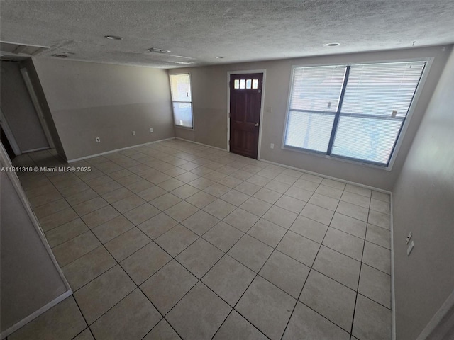 1521 Richmond Rd, Lakeland, FL 33805 - foyer featuring a textured ceiling, light tile patterned floors, and baseboards