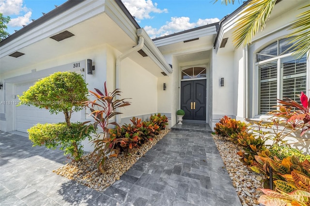 301 S Riverside, Pompano Beach, FL 33062 - doorway to property featuring stucco siding and a garage