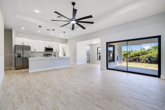 2709 58th St W, Lehigh Acres, FL 33971 - unfurnished living room with light wood finished floors, baseboards, ceiling fan, and recessed lighting