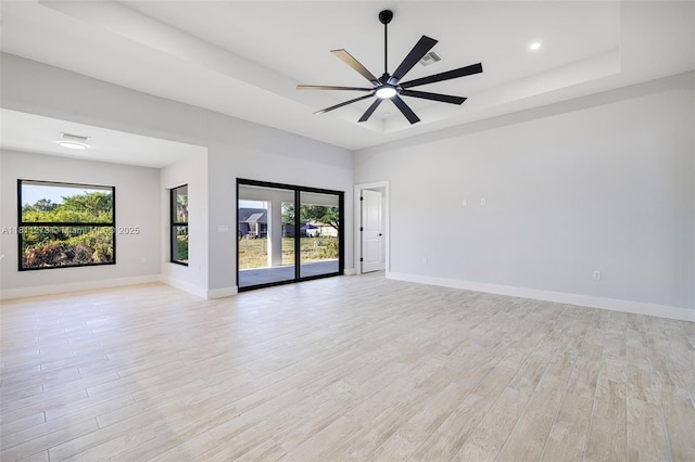 2709 58th St W, Lehigh Acres, FL 33971 - spare room featuring light wood finished floors, a raised ceiling, a ceiling fan, baseboards, and recessed lighting