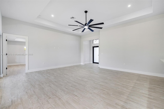 2709 58th St W, Lehigh Acres, FL 33971 - spare room with a raised ceiling, ceiling fan, light wood-style floors, recessed lighting, and baseboards