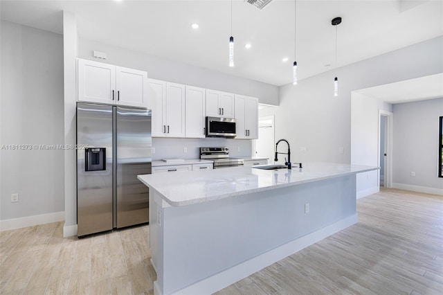 2709 58th St W, Lehigh Acres, FL 33971 - kitchen featuring appliances with stainless steel finishes, a sink, white cabinetry, a spacious island, and baseboards