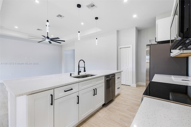 2709 58th St W, Lehigh Acres, FL 33971 - kitchen with a sink, stainless steel appliances, white cabinetry, a kitchen island with sink, and light wood-style flooring
