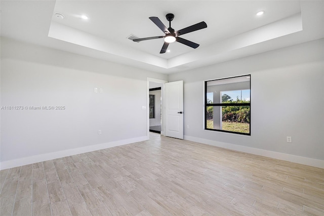 2709 58th St W, Lehigh Acres, FL 33971 - empty room with a tray ceiling, light wood-type flooring, baseboards, recessed lighting, and a ceiling fan