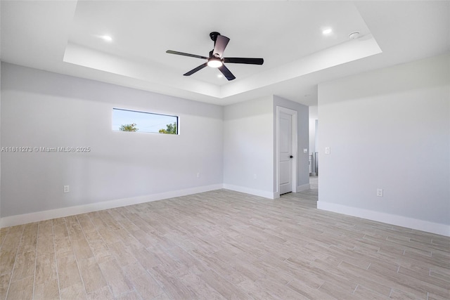 2709 58th St W, Lehigh Acres, FL 33971 - empty room featuring a raised ceiling, light wood-type flooring, ceiling fan, baseboards, and recessed lighting