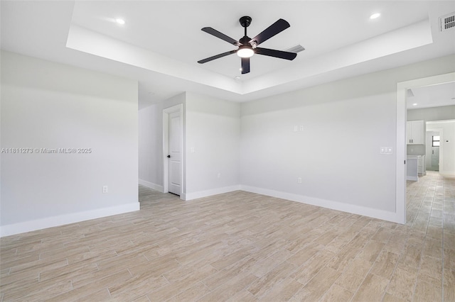 2709 58th St W, Lehigh Acres, FL 33971 - empty room with a raised ceiling, light wood-style floors, a ceiling fan, baseboards, and recessed lighting