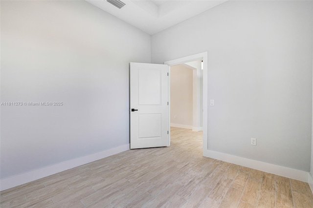 2709 58th St W, Lehigh Acres, FL 33971 - unfurnished room with light wood-type flooring, baseboards, and a high ceiling