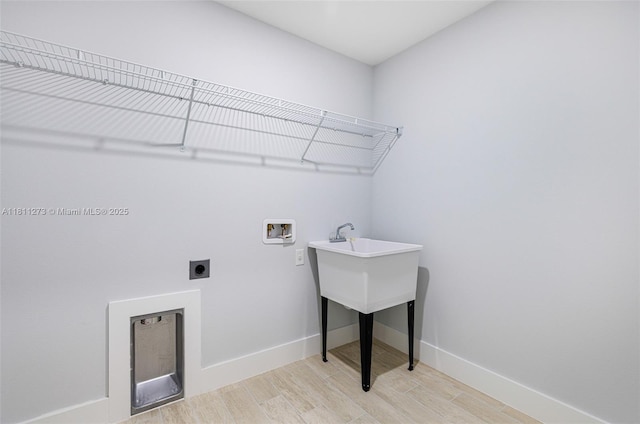2709 58th St W, Lehigh Acres, FL 33971 - laundry room with hookup for an electric dryer, hookup for a washing machine, light wood-type flooring, and baseboards