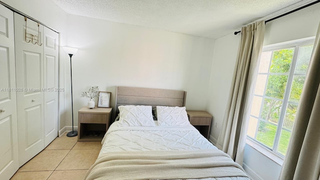 5122 NW 79th Ave Unit 301, Doral, FL 33166 - bedroom featuring multiple windows, a textured ceiling, light tile patterned floors, and a closet