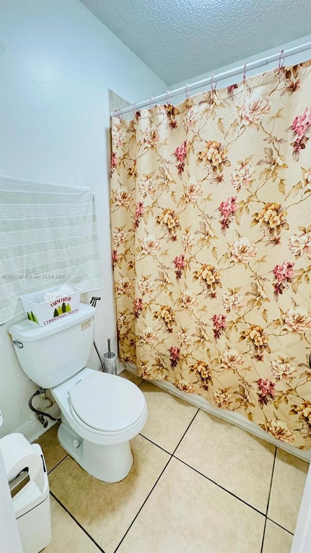 5122 NW 79th Ave Unit 301, Doral, FL 33166 - bathroom with toilet, a textured ceiling, tile patterned floors, and a shower with shower curtain