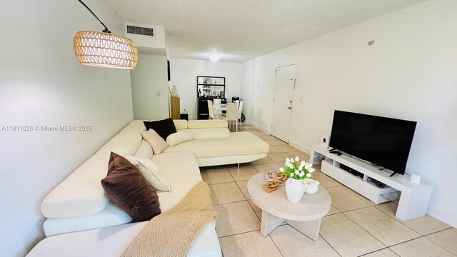 5122 NW 79th Ave Unit 301, Doral, FL 33166 - living room with light tile patterned floors, a textured ceiling, and baseboards