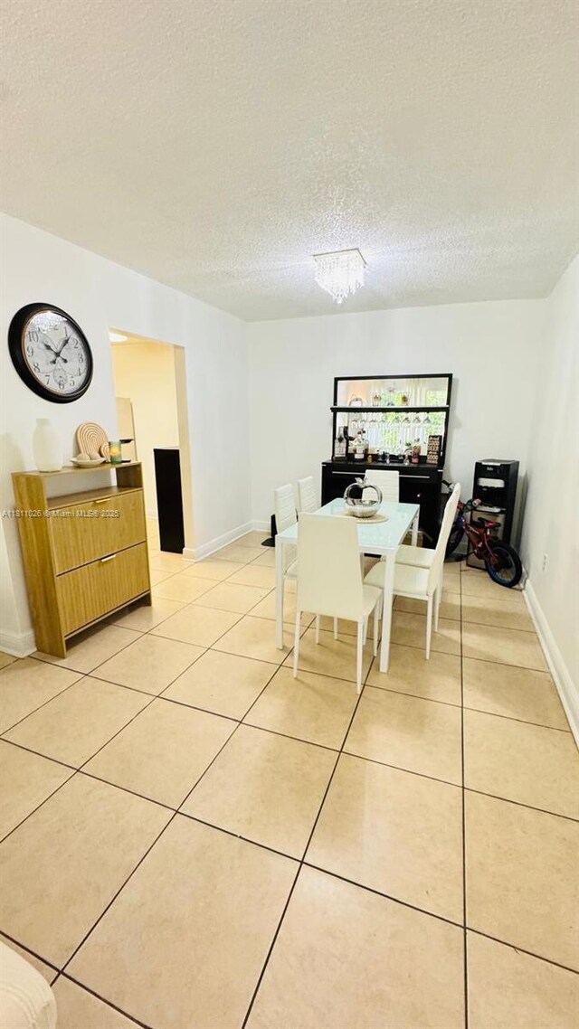 5122 NW 79th Ave Unit 301, Doral, FL 33166 - dining room featuring light tile patterned floors, a textured ceiling, and baseboards
