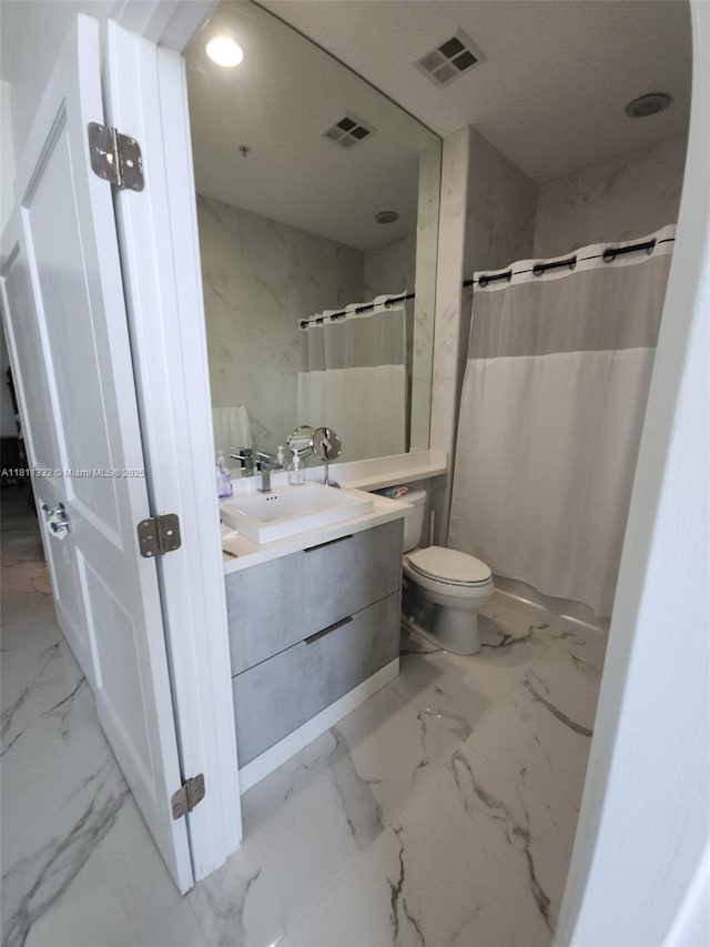 325 S Biscayne Blvd Unit 14, Miami, FL 33131 - bathroom with marble look tiles, vanity, toilet, and a shower with curtain