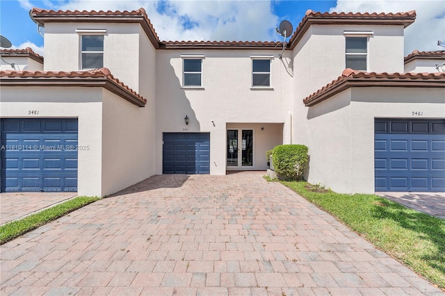 9471 SW 171st Pl, Miami, FL 33196 - mediterranean / spanish house with stucco siding, a tiled roof, decorative driveway, a garage, and french doors