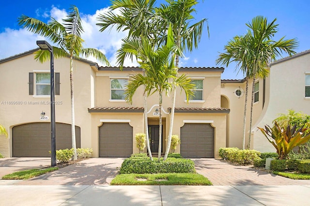 4631 Mediterranean Cir, Palm Beach Gardens, FL 33418 - view of front of property featuring driveway, stucco siding, a tiled roof, and a garage
