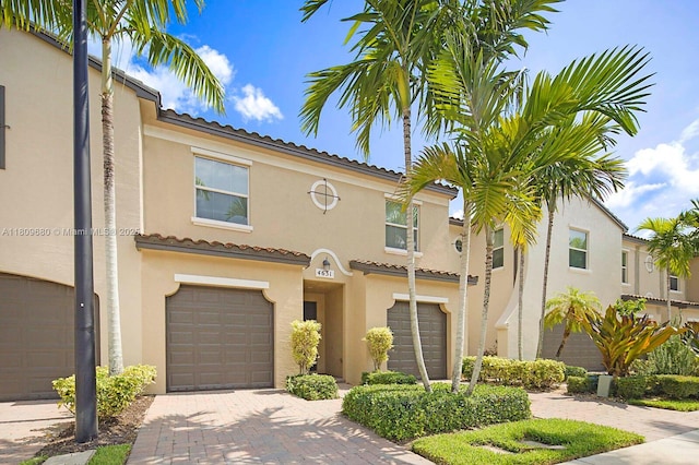 4631 Mediterranean Cir, Palm Beach Gardens, FL 33418 - view of front of house featuring an attached garage, stucco siding, decorative driveway, and a tiled roof