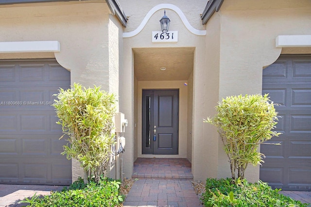 4631 Mediterranean Cir, Palm Beach Gardens, FL 33418 - entrance to property with a garage and stucco siding