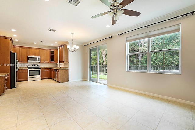 4631 Mediterranean Cir, Palm Beach Gardens, FL 33418 - kitchen featuring stainless steel appliances, brown cabinetry, a chandelier, recessed lighting, and light tile patterned floors