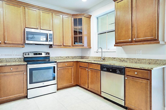 4631 Mediterranean Cir, Palm Beach Gardens, FL 33418 - kitchen featuring appliances with stainless steel finishes, crown molding, light stone countertops, glass insert cabinets, and brown cabinets
