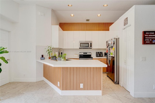1482 Canary Island Dr, Weston, FL 33327 - kitchen featuring stainless steel appliances, a peninsula, backsplash, light countertops, and recessed lighting