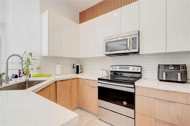 1482 Canary Island Dr, Weston, FL 33327 - kitchen with stainless steel appliances, a sink, modern cabinets, tasteful backsplash, and light stone counters