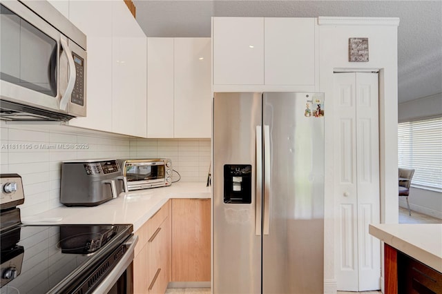 1482 Canary Island Dr, Weston, FL 33327 - kitchen featuring stainless steel appliances, modern cabinets, light countertops, decorative backsplash, and white cabinetry