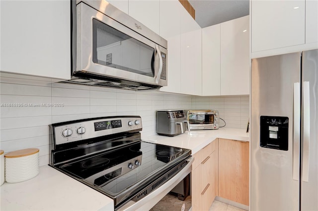 1482 Canary Island Dr, Weston, FL 33327 - kitchen with appliances with stainless steel finishes, modern cabinets, light countertops, decorative backsplash, and white cabinetry