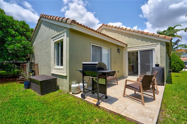 1482 Canary Island Dr, Weston, FL 33327 - back of property with a lawn, a patio, stucco siding, and a tile roof