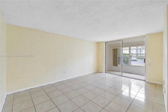 9091 Lime Bay Blvd Unit 110, Tamarac, FL 33321 - spare room featuring a textured ceiling, light tile patterned floors, and baseboards
