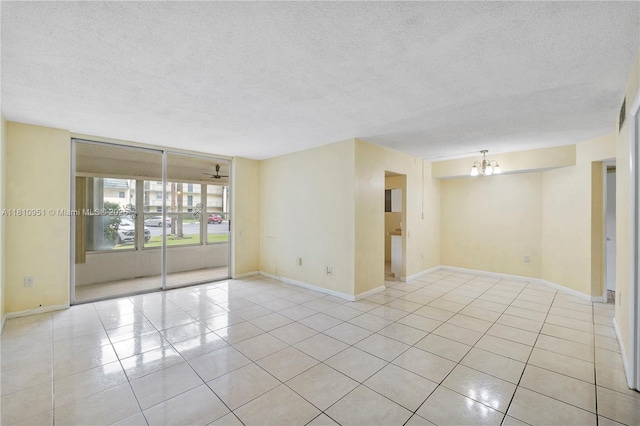9091 Lime Bay Blvd Unit 110, Tamarac, FL 33321 - empty room with a textured ceiling, a chandelier, light tile patterned floors, and baseboards