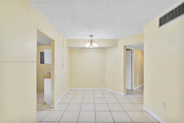 9091 Lime Bay Blvd Unit 110, Tamarac, FL 33321 - empty room featuring light tile patterned floors, a textured ceiling, a chandelier, and baseboards