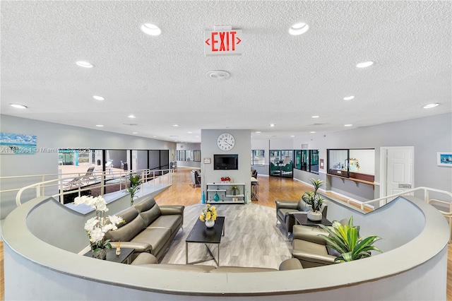 9091 Lime Bay Blvd Unit 110, Tamarac, FL 33321 - sunken living room featuring a textured ceiling, light wood-type flooring, and recessed lighting