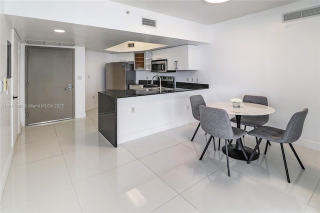 1750 N Bayshore Dr Unit 5214, Miami, FL 33132 - kitchen featuring stainless steel appliances, dark countertops, a peninsula, a sink, and white cabinetry