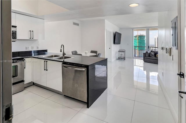 1750 N Bayshore Dr Unit 5214, Miami, FL 33132 - kitchen with stainless steel appliances, dark countertops, a sink, white cabinetry, and a peninsula