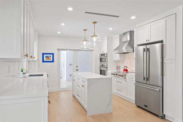 14270 SW 74th Ct, Palmetto Bay, FL 33158 - kitchen featuring stainless steel appliances, wall chimney range hood, a kitchen island, white cabinets, and recessed lighting