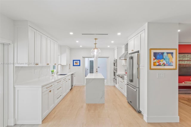 14270 SW 74th Ct, Palmetto Bay, FL 33158 - kitchen with stainless steel appliances, extractor fan, a sink, a center island, and light wood-style floors