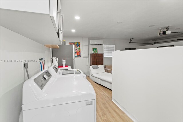14270 SW 74th Ct, Palmetto Bay, FL 33158 - laundry room featuring washing machine and dryer, an AC wall unit, and light wood-style flooring