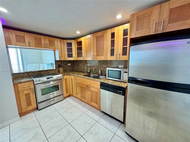 5555 Collins Ave Unit 6E, Miami Beach, FL 33140 - kitchen featuring appliances with stainless steel finishes, a sink, decorative backsplash, glass insert cabinets, and recessed lighting