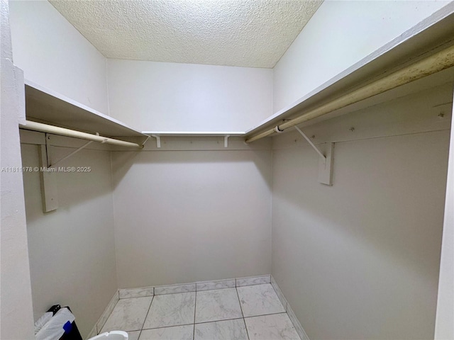 5555 Collins Ave Unit 6E, Miami Beach, FL 33140 - walk in closet featuring marble look tile flooring