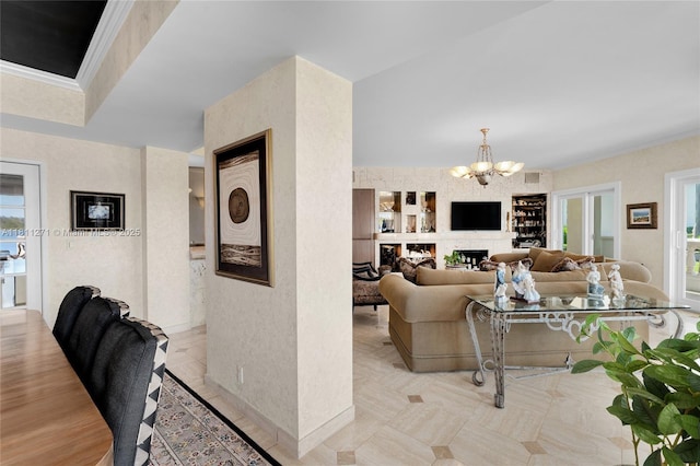 2213 Fisher Island Dr Unit 3103, Miami Beach, FL 33109 - living room featuring a chandelier, crown molding, a fireplace, and built in shelves