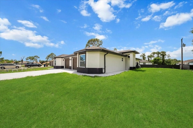 4800 Nelson Dr, Lehigh Acres, FL 33973 - back of house with concrete driveway, a garage, and stucco siding