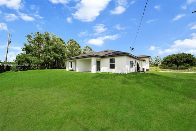 4800 Nelson Dr, Lehigh Acres, FL 33973 - view of side of home with a lawn and stucco siding