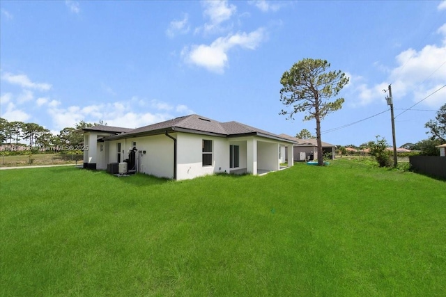 4800 Nelson Dr, Lehigh Acres, FL 33973 - back of property with stucco siding, a yard, and a shingled roof