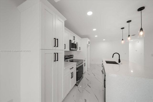 4800 Nelson Dr, Lehigh Acres, FL 33973 - kitchen featuring appliances with stainless steel finishes, a sink, light marble finish flooring, recessed lighting, and white cabinetry