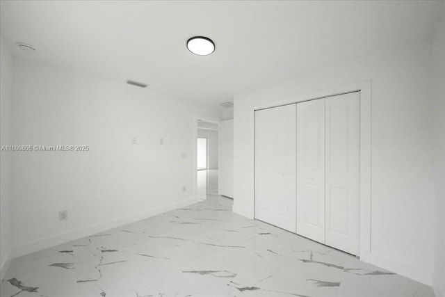4800 Nelson Dr, Lehigh Acres, FL 33973 - unfurnished bedroom with baseboards, marble look tiles, and a closet