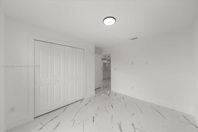 4800 Nelson Dr, Lehigh Acres, FL 33973 - unfurnished bedroom featuring baseboards, marble finish flooring, and a closet