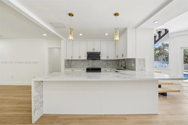 2001 SW 23rd Ave, Fort Lauderdale, FL 33312 - kitchen featuring stainless steel microwave, a sink, light stone countertops, white cabinets, and recessed lighting