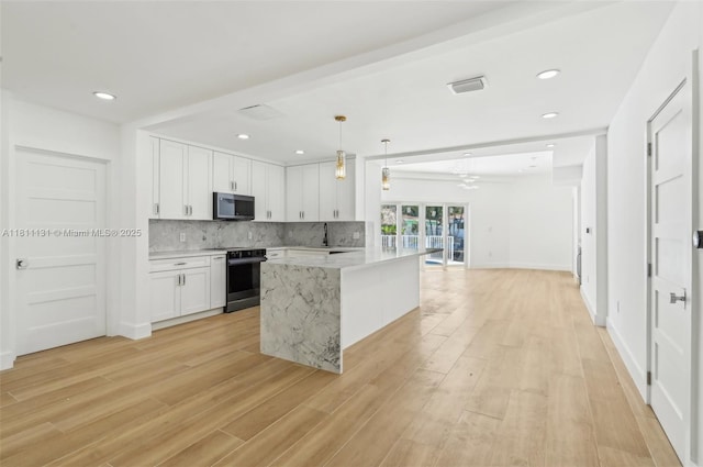 2001 SW 23rd Ave, Fort Lauderdale, FL 33312 - kitchen featuring stainless steel microwave, electric range oven, white cabinetry, backsplash, and light wood-type flooring